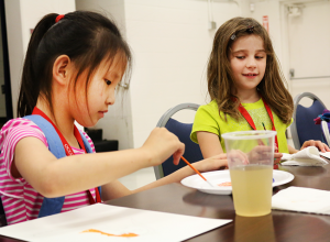 Victoria, 7, and Isabella, 7, paint pictures in the FACE Center's cafeteria for the Picasso Art camp on June 17. Jake McMahon / Pioneer