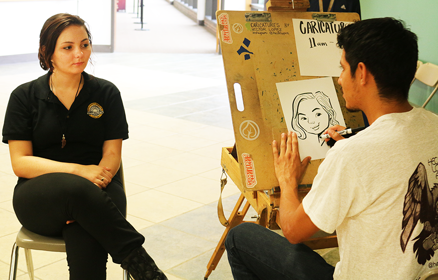 Ashlynn Chumard sits for a caricature by caricature artist Hector Lopez