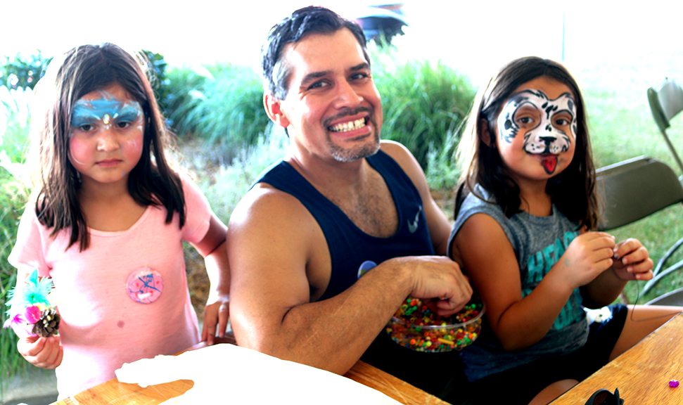 Grace, 5, and Brileigh, 7, make necklaces with their father Damon