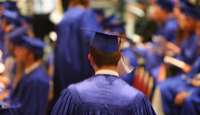 A generic photo of a graduate in their cap and gown.