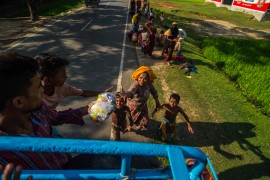 In Myanmar, people are starving and homeless. A young girl seeks a safe haven under a cloth tent. Refugees swarm a truck in search of food while a young boy looks on. Trucks filled of bags of rice wait to be unloaded. Refugees search for food among piles of useless donated clothes while children race for candy being thrown from a truck. Pioneer Photos by Rahul Chaktaborty and Shantonu Paul  